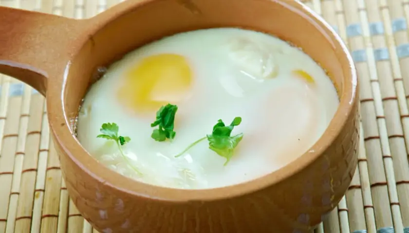 Un œuf cocotte crémeux, cuit au four, garni de persil frais. Un délice simple et réconfortant.