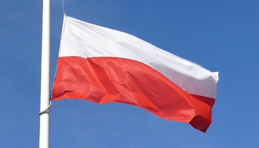 Biało-czerwona flaga Polski powiewa na maszcie na tle błękitnego nieba. Czy żałoba jest obowiązkowa?