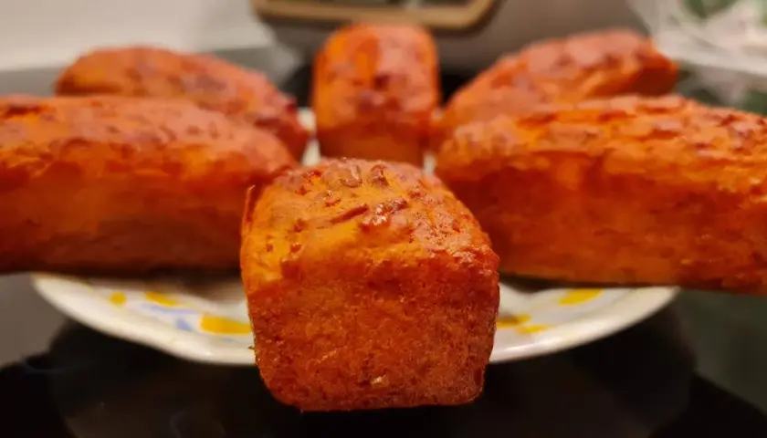 Petits pains dorés, peut-être un cake chorizo, sur une assiette.