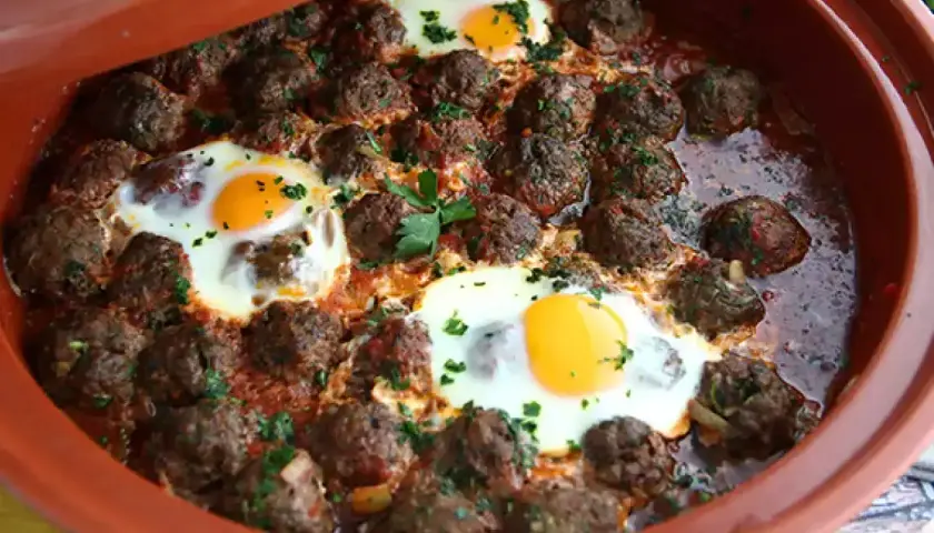 Köttbullar med ägg i tomatsås i en tagine. Ett smakrikt tagine recept som passar perfekt för en mysig middag.