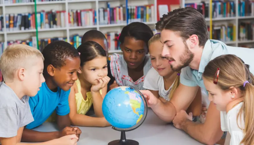 Ein guter Lehrer erklärt Kindern die Welt mit einem Globus.