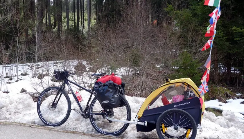 Bicicletta con rimorchio per bambini, pronta per vacanze in bici con bambini, con bandierine internazionali.