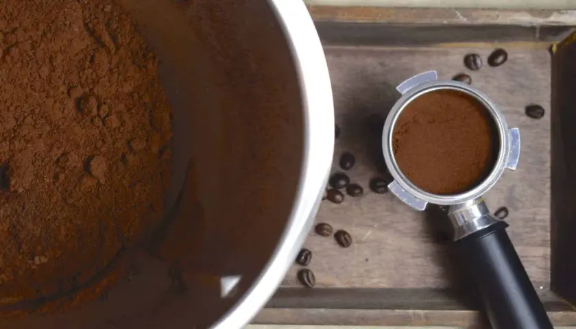 Frisch gemahlene Kaffeebohnen im Thermomix-Behälter und im Siebträger. Der Duft von frisch gemahlenem Kaffee liegt in der Luft.