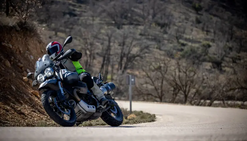 Motociclista en curva, con casco y equipo de aventura. Las llantas Continental TKC 70 opiniones son clave para este terreno.