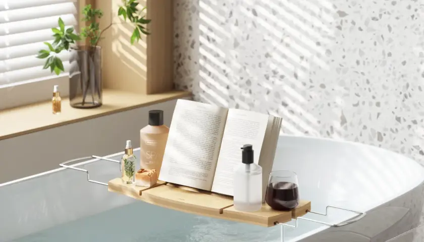 Relaks w wannie jak w spa: książka, kosmetyki i napój na tacce. Idealne miejsce na odprężenie.