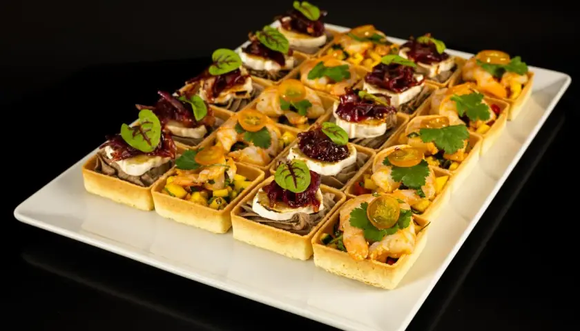 Elegancki catering na konferencje: tartaletki z krewetkami i mango oraz z kozim serem i konfiturą z czerwonej cebuli.
