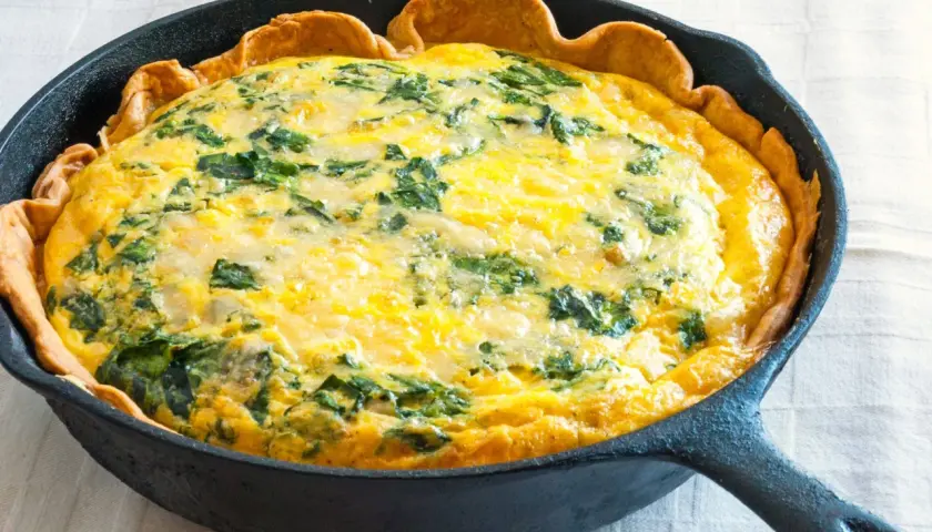 Quiche aux épinards dans une poêle en fonte. Une idée parfaite pour savoir que faire avec 3 jaunes d'œufs restants.