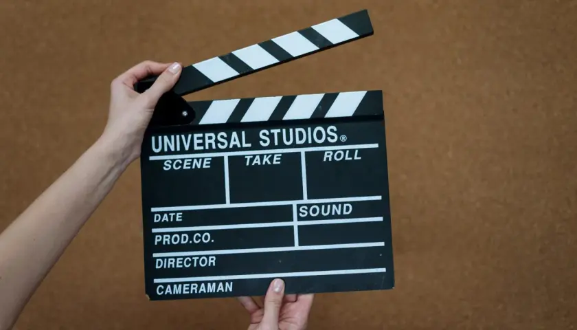 Mani che tengono una ciak Universal Studios, pronta per girare. Un vero cinefilo significato di inizio riprese.