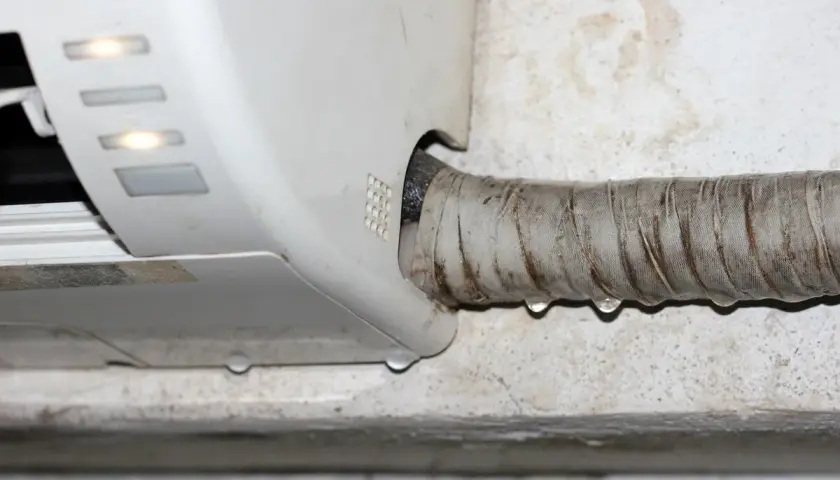Goteo de agua en la manguera de un aire acondicionado, indicando la necesidad de saber como vaciar el agua del aire acondicionado.