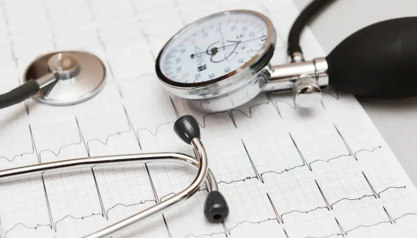 Stetoskop i ciśnieniomierz na tle EKG. Dbanie o serce, jak przyjmowanie leku Valsacor, jest kluczowe.