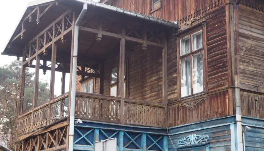 Drewniana willa z werandą, ozdobnymi balustradami i okiennicami, część szlaku świdermajerów.