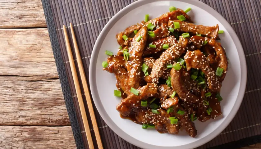 Wołowina w sosie teriyaki, posypana sezamem i szczypiorkiem, idealna do ryżu lub makaronu.