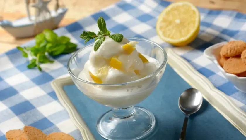 Sorbetto al limone, fresco e cremoso, preparato con la gelatiera, guarnito con menta e scorzette.