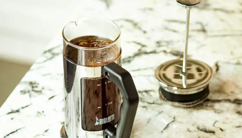Elegancka kawiarka Bialetti z zaparzoną kawą po francusku. Gotowa do delektowania się aromatycznym napojem.