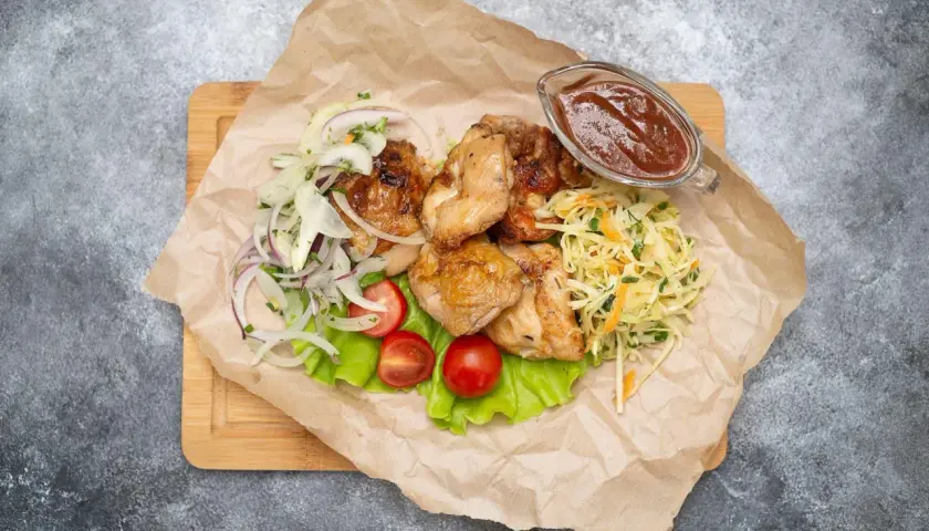 Grillowany kurczak z surówką z kapusty, cebulą, pomidorkami i sosem.