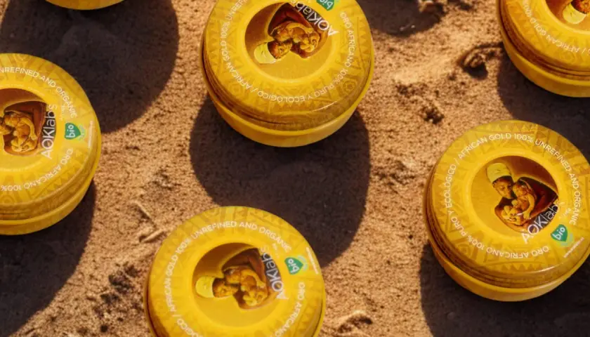 Latas de manteca de karité para el pelo, oro africano 100% puro y ecológico, sobre arena.