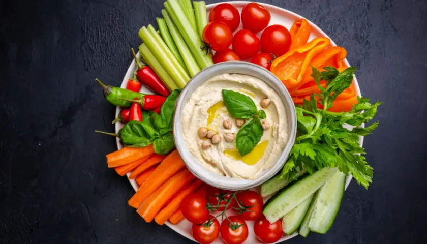 Bunte Gemüsesticks mit Hummus – ein köstliches veganes Fingerfood. Karotten, Gurken, Paprika, Sellerie, Tomaten und Chili laden zum Dippen ein.