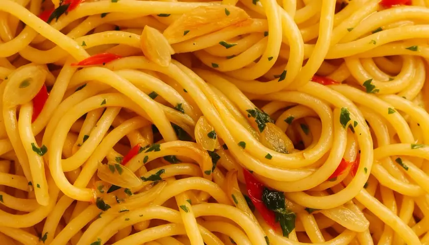 Nahaufnahme von Spaghetti Aglio e Olio, dem originalen Gericht mit Knoblauch, Chili und Petersilie.