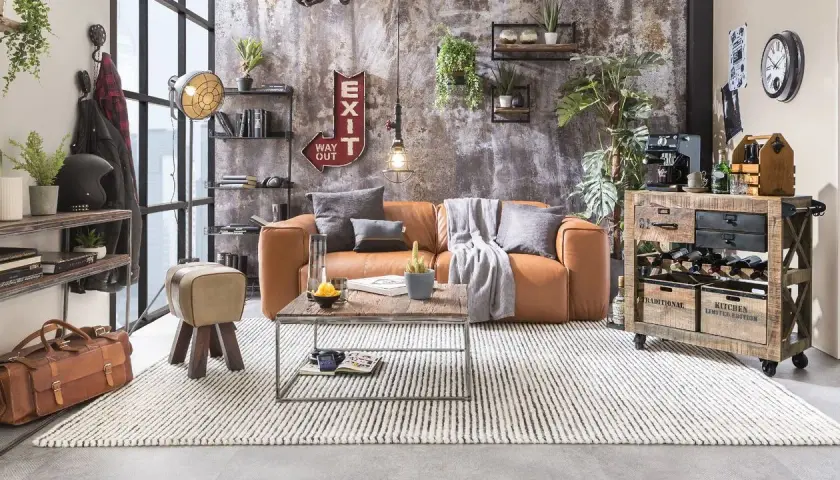 Gemütliches Wohnzimmer im **retro stil** mit cognacfarbenem Sofa, Holztisch und rustikalem Weinregal.
