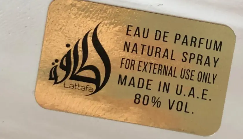Złota naklejka z napisem Lattafa i logo. Woda perfumowana, spray naturalny, do użytku zewnętrznego, wyprodukowano w ZEA. Qaed Al Fursan Unlimited.