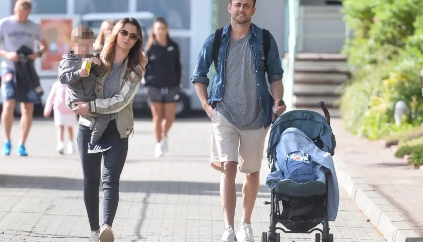 Para spacerowa: kobieta z dzieckiem na rękach i mężczyzna pchający wózek. Czy Fabiański ma dzieci? Tak, wygląda na to, że tak.