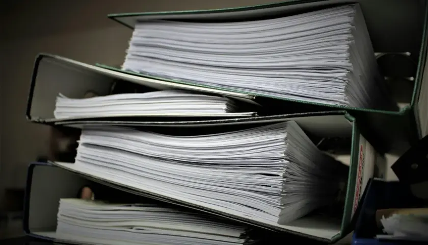 Stosy segregatorów z dokumentami. Szukasz informacji, jak znaleźć numer księgi wieczystej?
