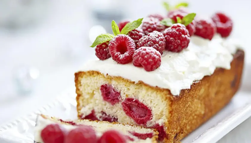 Un délicieux framboisier gateau, garni de framboises fraîches et de crème fouettée, prêt à être dégusté.