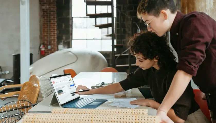 Dwie osoby analizują stronę internetową z meblami, zastanawiając się, co to jest d2c i jak to działa.