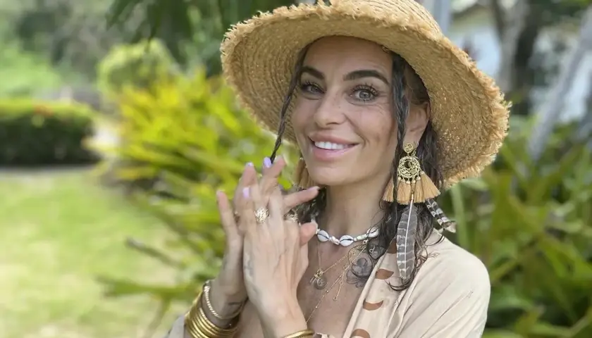 Kasia nastraja pozytywnie w słomkowym kapeluszu i boho biżuterii, uśmiecha się na tle zieleni.