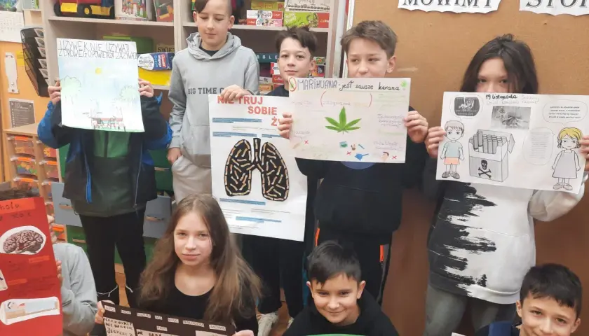 Dzieci trzymają plakaty o szkodliwości używek, m.in. o marihuanie i papierosach.