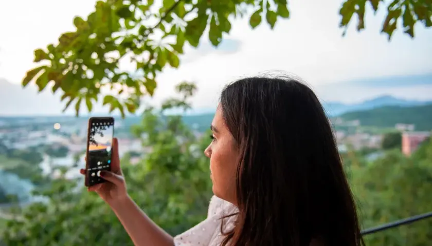 Kobieta robi zdjęcie telefonem, ale widać pogorszenie jakości zdjęć w telefonie.