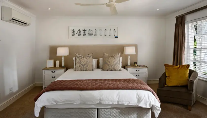 Luxurious hotel bedding layers, featuring crisp white sheets, decorative pillows, and a warm throw, invite a restful night's sleep.