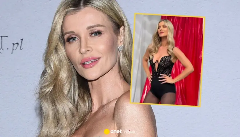Joanna Krupa figura w czarnym, wyciętym body i rajstopach. Włosy blond, makijaż.