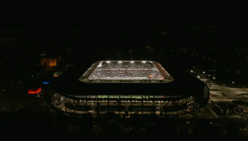 Nocny widok stadionu Górnik Zabrze. Trybuny wypełnione kibicami, widoczny napis "KLUB SPORTOWY GÓRNIK ZABRZE NASZYM ŻYCIEM". Pojemność stadionu robi wrażenie.