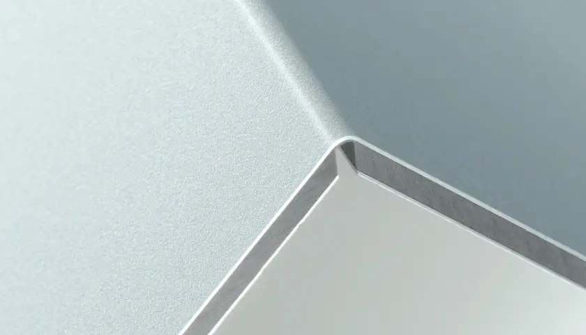 Szara, matowa powierzchnia z połyskującą krawędzią, przypominająca nowoczesny panel alucobond.