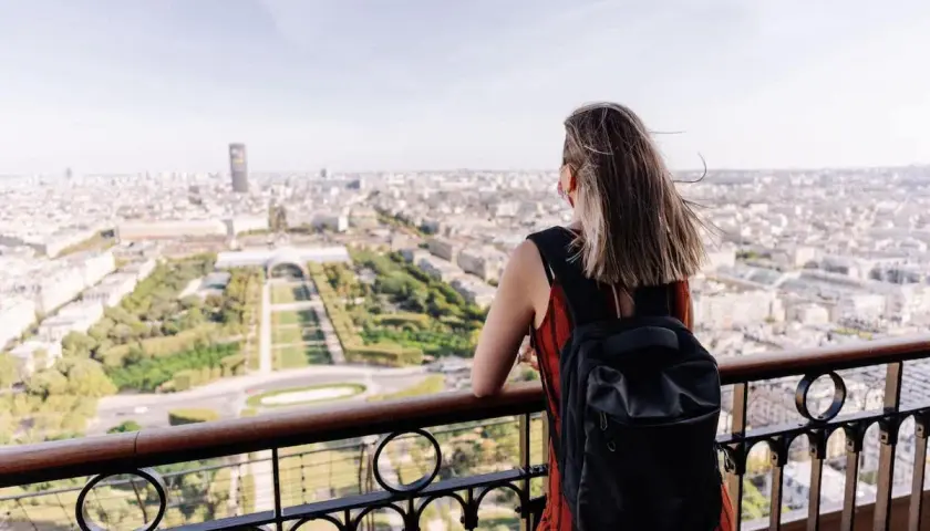 Kobieta z plecakiem podziwia panoramę Paryża. To idealny czwartek po francusku, pełen słońca i widoków.