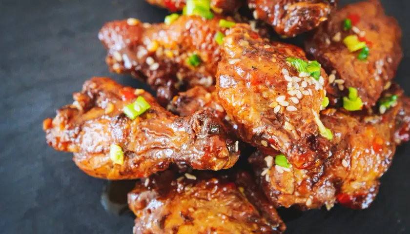 Ailes de poulet croustillantes, nappées d'une sauce sucrée et salée, garnies de graines de sésame et de ciboule. Un délice de marinade poulet.
