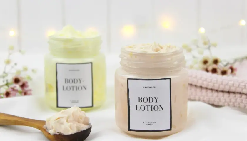 Zwei Gläser mit selbstgemachter Bodylotion, eine auf einem Holzlöffel.