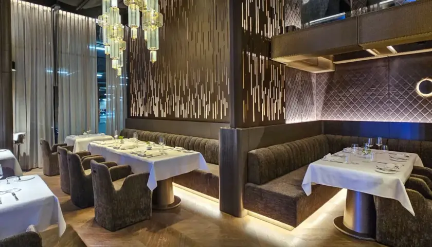 Eleganckie wnętrze restauracji w Poznaniu, z białymi obrusami i nowoczesnym designem. Idealne miejsce na odkrycie nowych restauracji w Poznaniu.