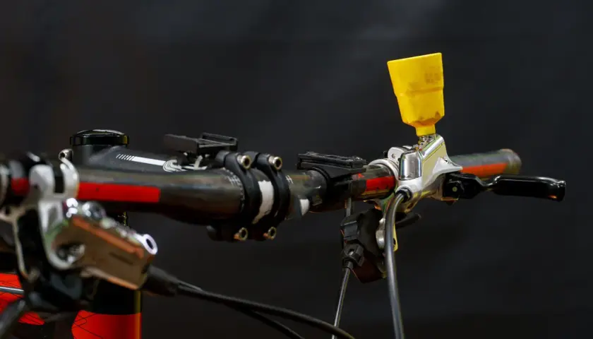 Żółty lejek na kierownicy roweru, gotowy do akcji. To kluczowy element, by wiedzieć, jak odpowietrzyć hamulce i cieszyć się bezpieczną jazdą.