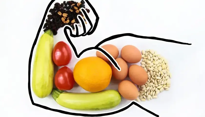 Zdrowa dieta to klucz do tego, jak podbic testosteron. Na talerzu: cukinia, pomidory, pomarańcza, jajka, fasola i bakalie.