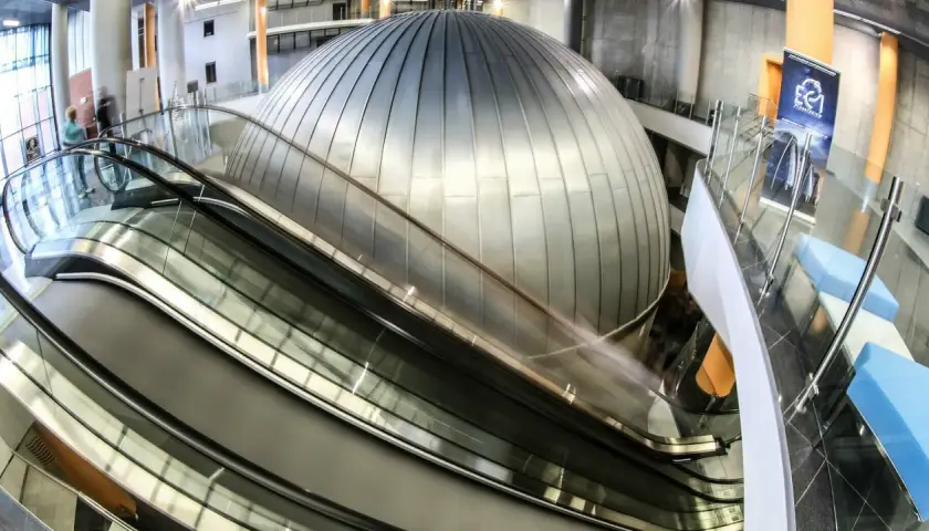 Nowoczesne wnętrze z kopułą i ruchomymi schodami. EC1 Planetarium to miejsce, które warto zobaczyć, pełne naukowych atrakcji.