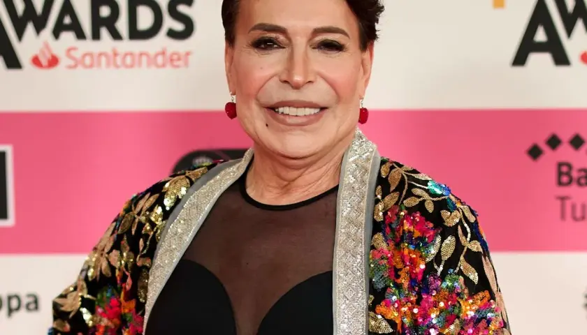 Benita Maestro Joao sonríe en la alfombra roja, luciendo una chaqueta colorida y brillante.