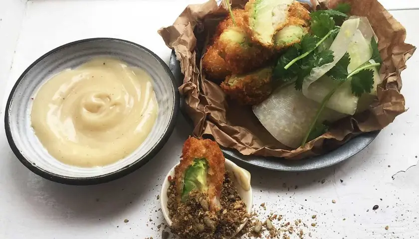 Krispigt friterad avokado med en krämig dipp och fräscha grönsaker. En perfekt snack!