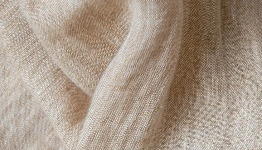 Texture naturelle du lin, évoquant la douceur et la qualité de sa fabrication.