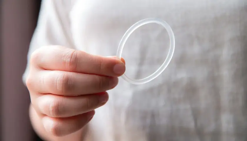 Dłoń trzyma przezroczysty ring dopochwowy.