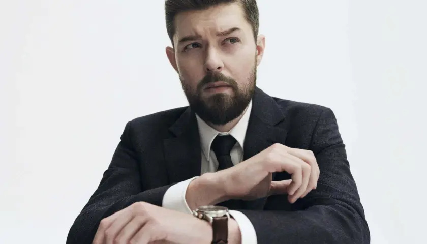Remigiusz Mróz, znany pisarz, w eleganckim garniturze, z zamyśloną miną. Może planuje kolejną premierę książki, a może wizytę u dentysty?