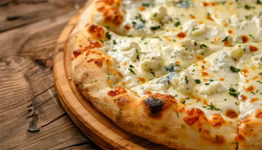 Pyszna pizza z serem, z chrupiącą skórką i obficie posypana ziołami, prezentuje się apetycznie na drewnianej desce.