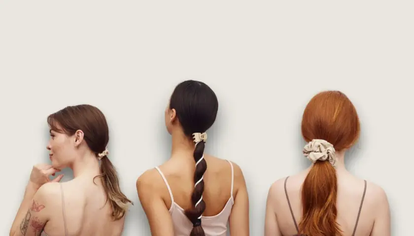 Tre kvinnor med olika frisyrer. En har en tofs i håret, en annan en fläta med band och den tredje en hästsvans med scrunchie.