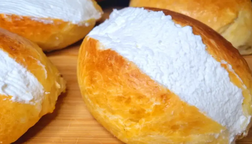 Maritozzi ricetta originale: soffici panini dolci farciti con abbondante panna montata, pronti per essere gustati.